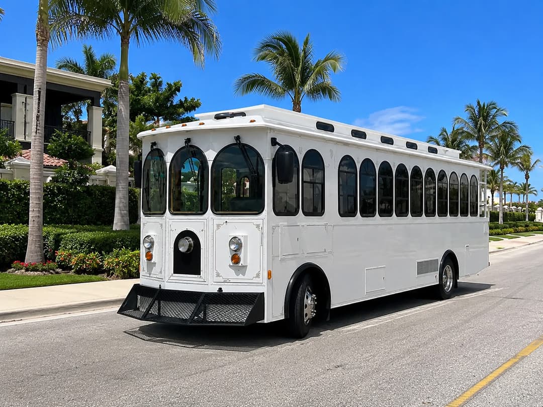 White Rent A Trolley trolley on a palm-lined street, available for Boynton Beach weddings and marina events