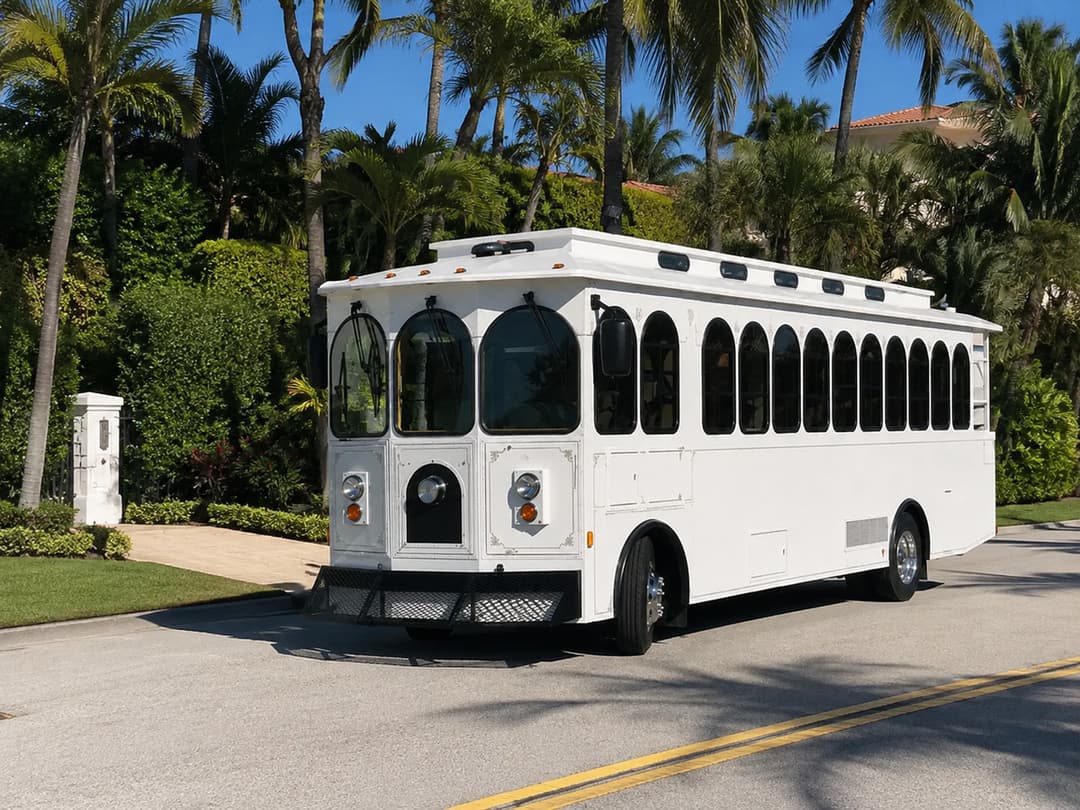 White Rent A Trolley trolley parked at a hedged entrance, available for Jupiter weddings and waterfront events