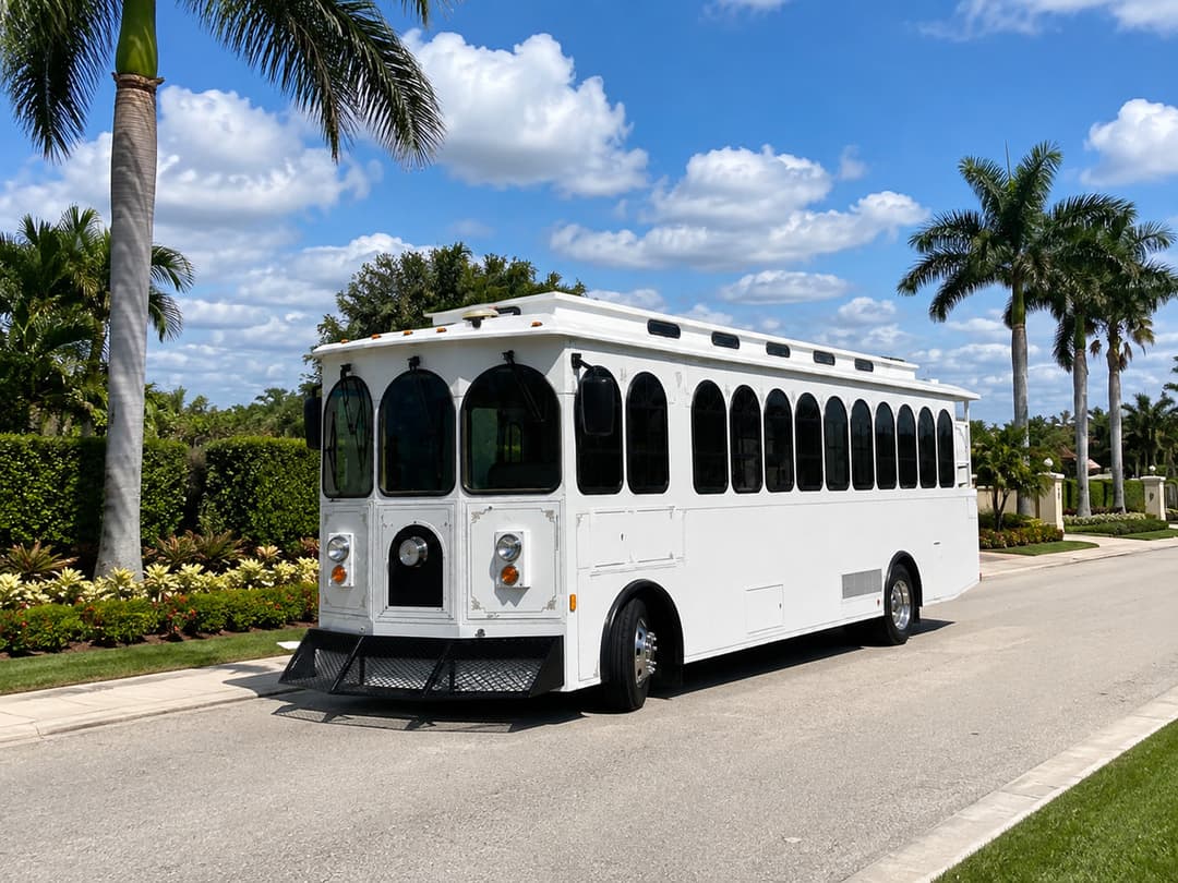 White Rent A Trolley trolley on a palm-lined village street, available for Wellington equestrian events and barn weddings